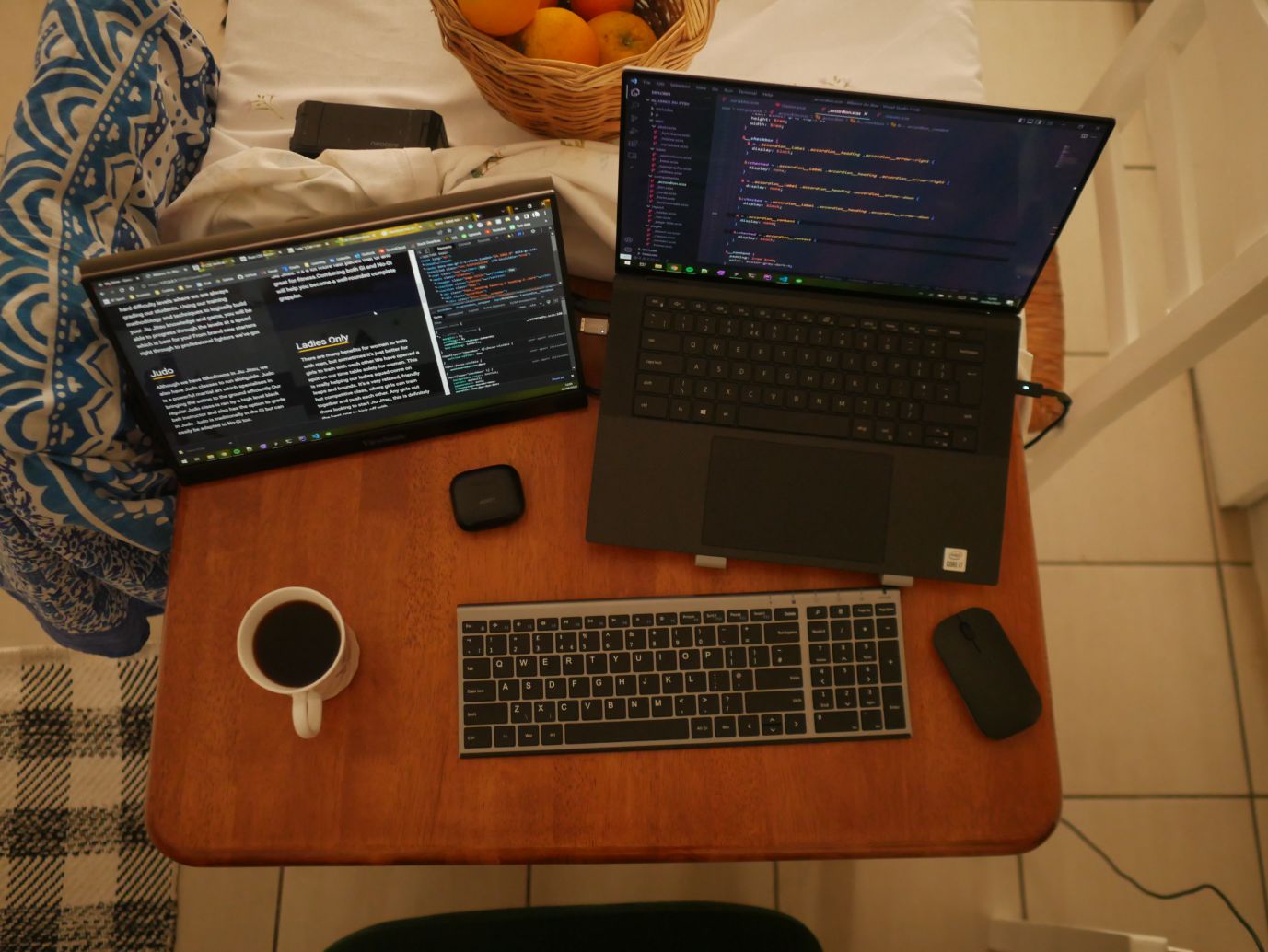 Lucian Chevallier's desk setup while trying out the digital nomad lifestyle. A laptop, portable second screen and wireless keyboard and mouse.